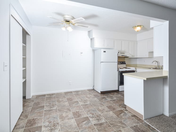 Kitchen with White Appliances and Tile Style Flooring through the Kitchen and Dining Room