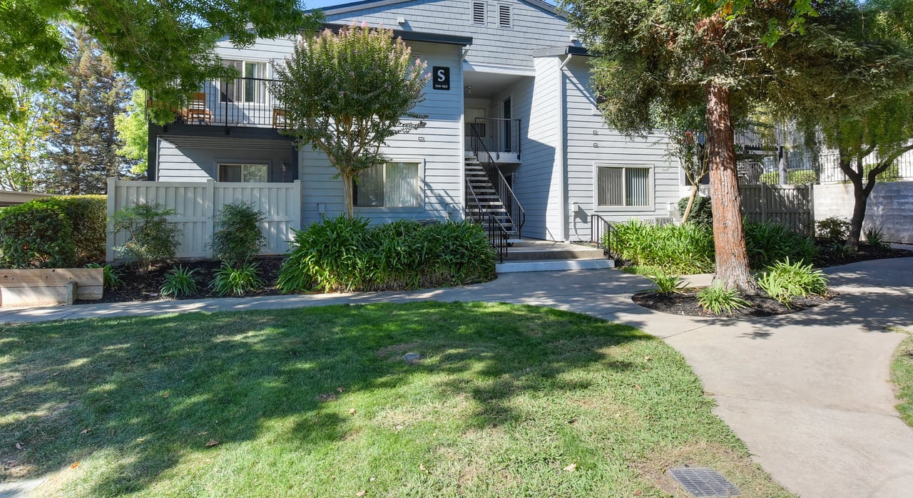 Exterior of Apartment Building with Walk Path, Front Door Entances, Grass, Trees