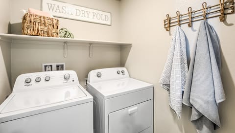 Homes in Reno-Aspen Vista at Anchor Pointe Apartments Laundry Room With Washer And Dryer With Shelf And Hanging Rack