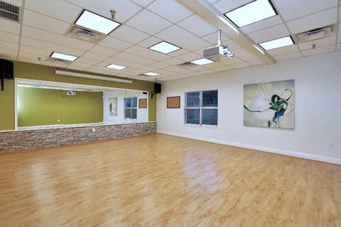 Spacious Yoga Room with Large Mirror and Hardwood Floors