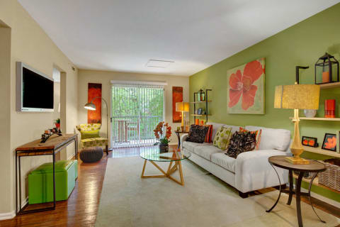 Landover Apartments - Spacious Living Room with Faux-Wood Plank Flooring and Sliding Doors to Patio