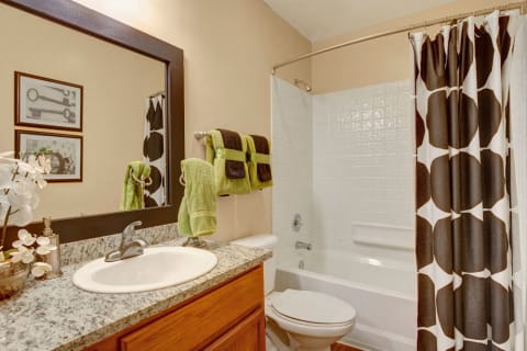Landover Apartments - The Villages at Morgan Metro Bathroom with Large Shower and Tub, Spacious Countertop, and Ample Storage Space