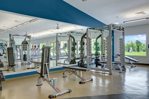 Apartments for Rent in Landover MD - The Villages at Morgan Metro Fitness Center with Mirrored Walls, Weight Machines, and Various Cardio Equipment