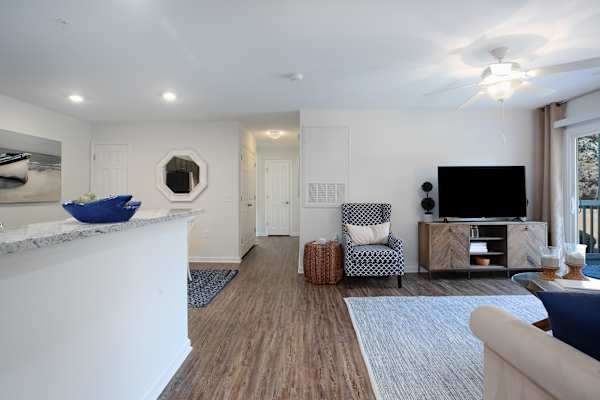 A living room with a white fireplace, a blue chair, and a television.