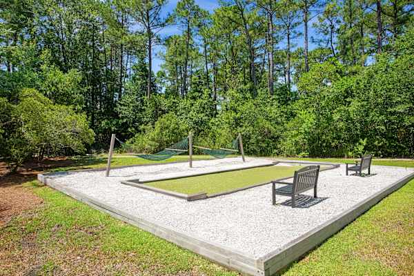 A backyard with a swing set and a sandbox.
