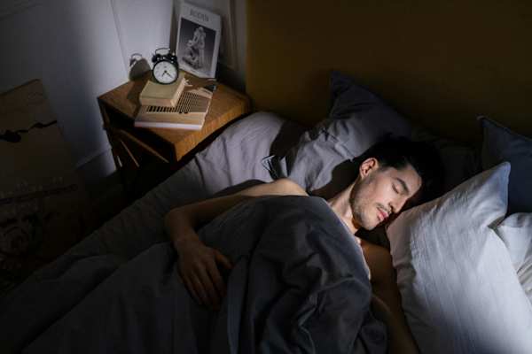 A man sleeping in bed at Twenty Fair Apartments, New Haven, CT, 06511