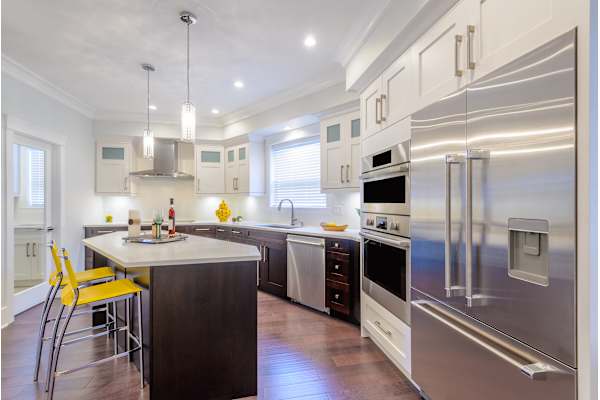 A modern kitchen with a center island and stainless steel appliances.