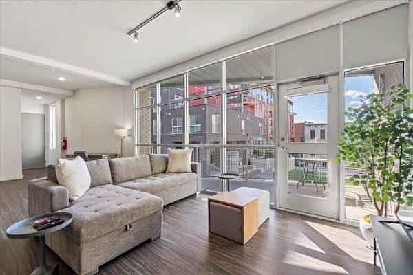 A modern living room with a grey sofa and a wooden coffee table. at Paperbox Lofts Apartments, Salt Lake City  , UT, 84101