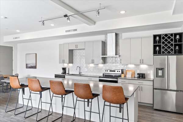 A modern kitchen with a bar area and chairs. at Paperbox Lofts Apartments, Salt Lake City  , 84101