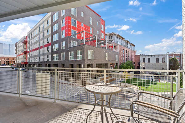 A red and grey building with a table and chairs in front. at Paperbox Lofts Apartments, Salt Lake City