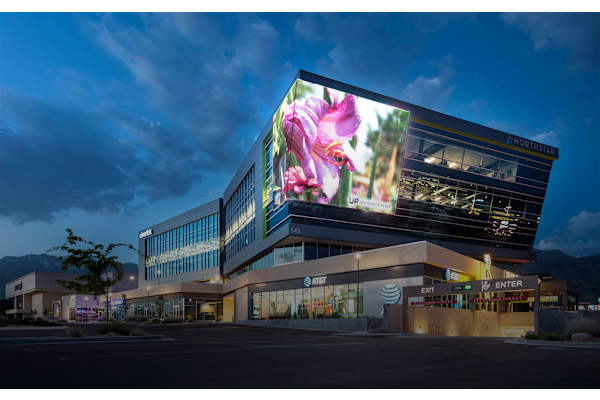 A modern building with a large screen displaying a flower on it. at Siena Villas Apartments, Orem, 84097