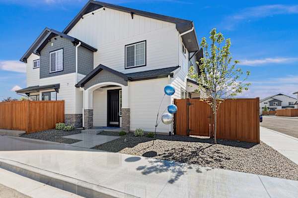 A modern house with a grey and white exterior and a wooden fence. at AVIA Lofts on Victors Way, Boise, ID