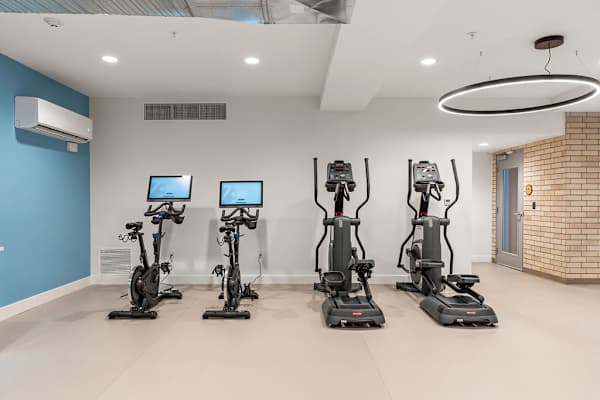 A room with exercise bikes and a blue wall. at The Revival, Salt Lake City