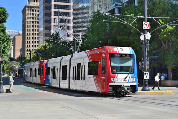 A red and white train is on the tracks in a city. at Paperbox Lofts Apartments, Apartments, Salt Lake City  , UT