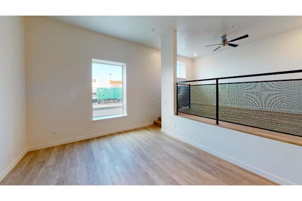 A room with a window and a fan.
