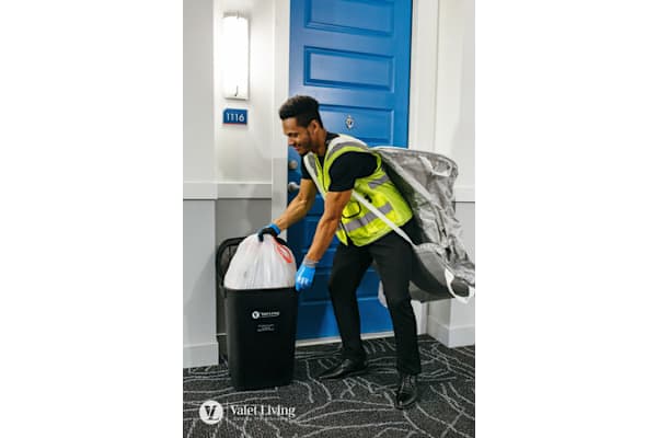 Man in yellow vest and blue gloves is taking out the trash at Solhavn Apartments, American Fork, UT, 84003