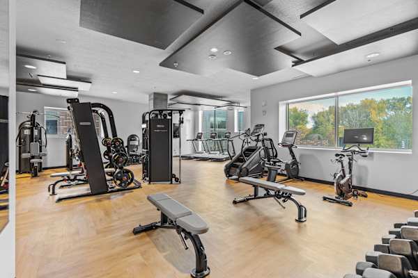 A gym with a variety of equipment including treadmills, weights, and exercise bikes at Wilmington Flats Apartments, Utah
