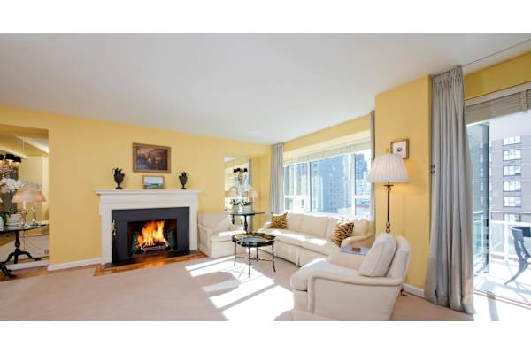 a living room with yellow walls and a fireplace