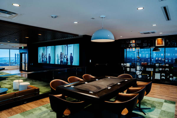 a conference room with a table and chairs and a large screen