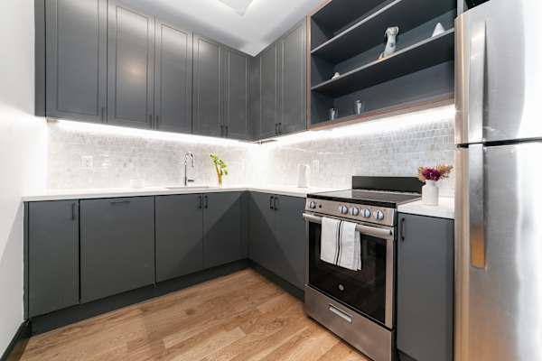 A modern kitchen with a stainless steel refrigerator and a black oven.