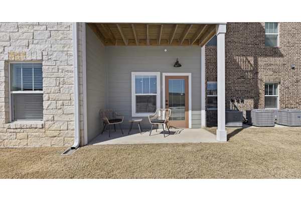 A house with a stone wall and a covered patio.