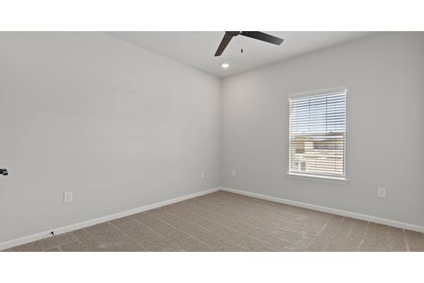 A room with a ceiling fan and a window with blinds.