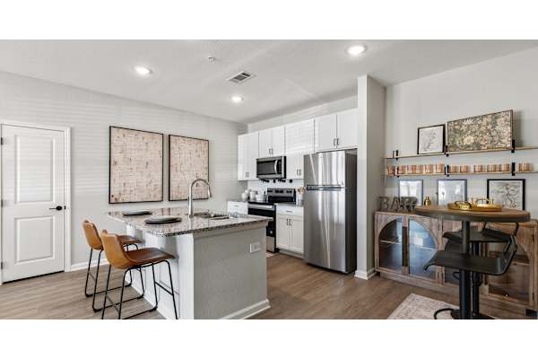 A kitchen with a white countertop and a stainless steel refrigerator.