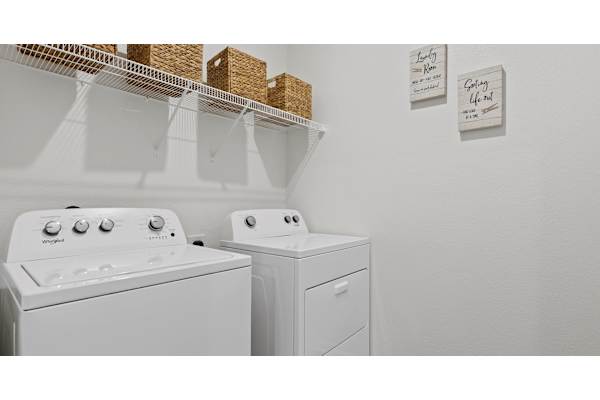 Two white washing machines in a laundry room.