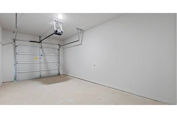 A white wall with a shelving unit and a light fixture.