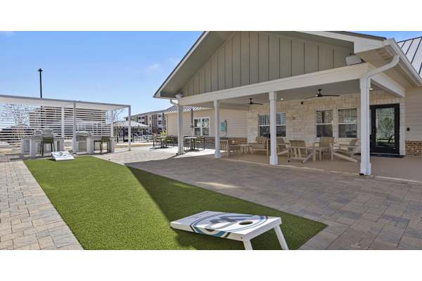 A patio area with a table and chairs under a roof.