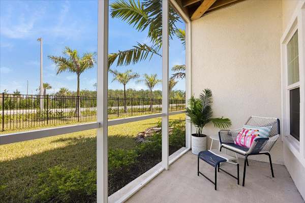 A patio with a chair and a potted plant.