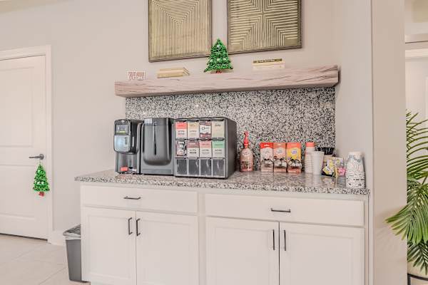 A kitchen counter with a variety of containers and a small Christmas tree.