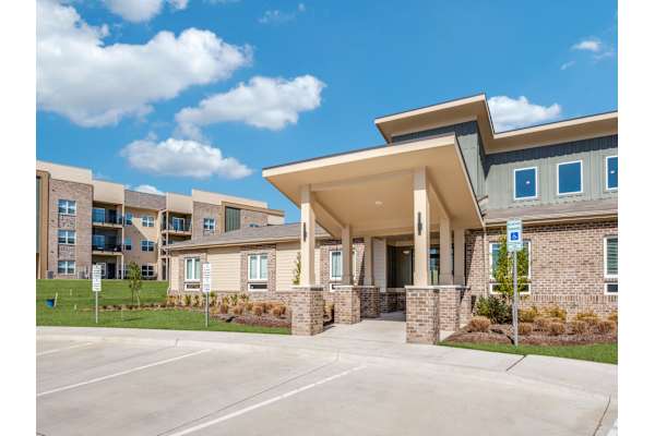 A modern building with a parking lot in front.
