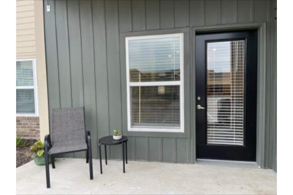 a patio with a chair and a table in front of a door