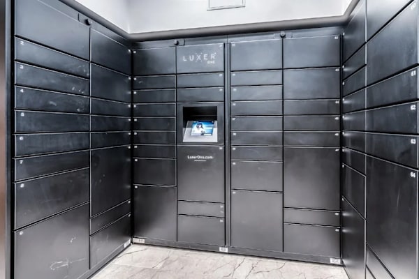 A black room with a screen and the word "LUXE" on the wall.