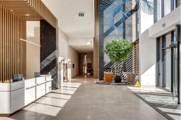 A long hallway with a plant in a pot on the right side.