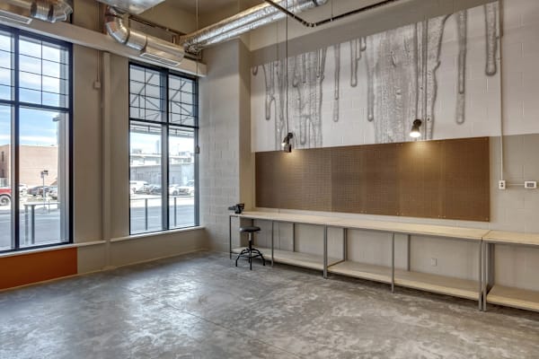 A room with a large window and a wall with a painting of dripping paint.