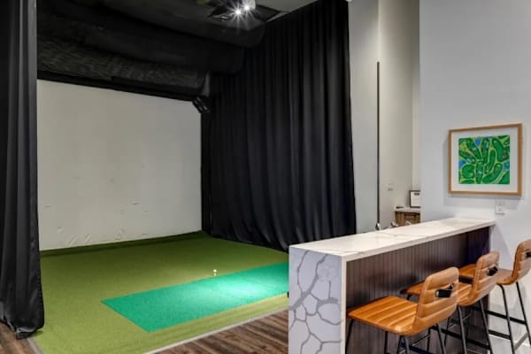 A yoga studio with a green mat on the floor.