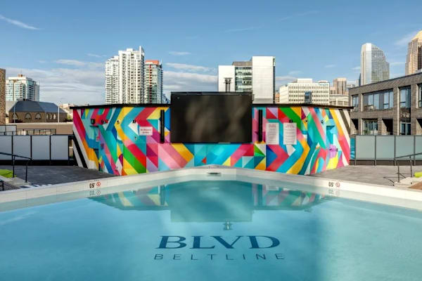 A pool with a colorful mural on the side and the words "BLVD Beltline" written on the water.