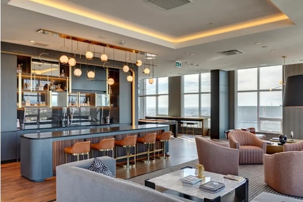 A modern living room with a bar area and a view of the city.