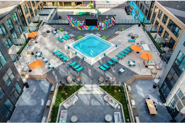 An aerial view of a pool surrounded by lounge chairs and umbrellas.