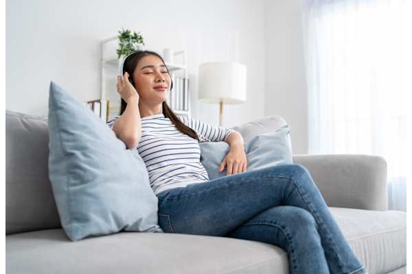 A woman is sitting on a couch at The Maverick Apartments, Ontario