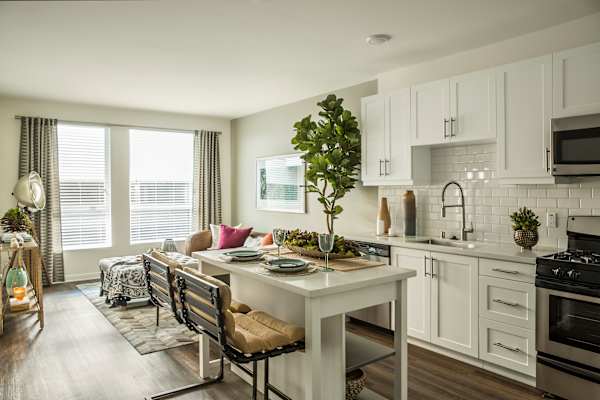 an open kitchen and living room with a table and chairs