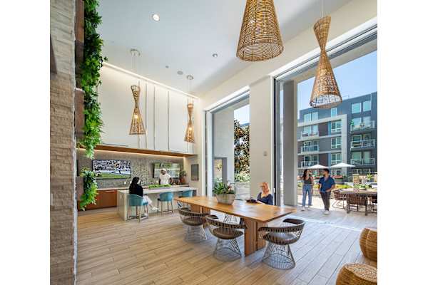 a rendering of a communal area with a dining table and chairs