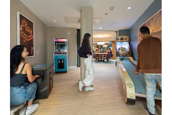 a man and a woman are standing in a room next to a bowling alley