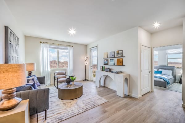 an open living room with a fireplace and a bedroom in the background