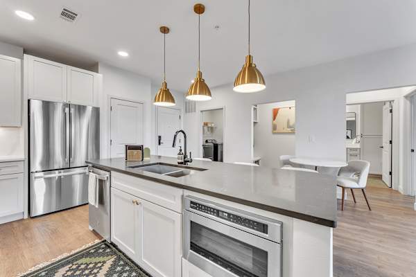 The Plaza at Pinnacle Hills open concept kitchen with large kitchen island with designer pendant lighting