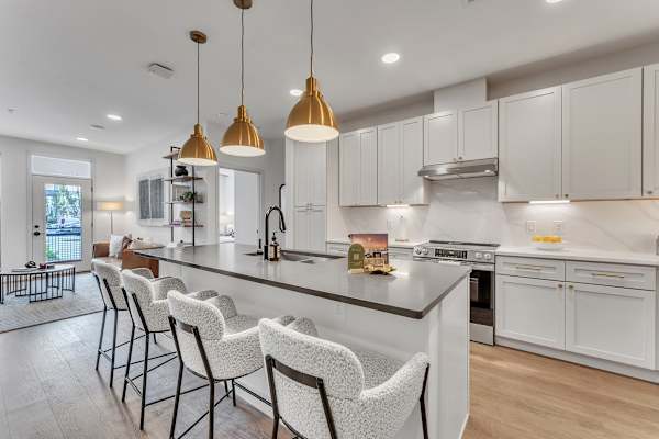 The Plaza at Pinnacle Hills open concept kitchen with large kitchen island, seating, black finishes and designer lighting