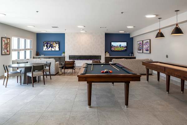 A room with a pool table and a bar.
