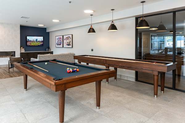A pool table with a green felt cloth and white balls is in the center of the room.